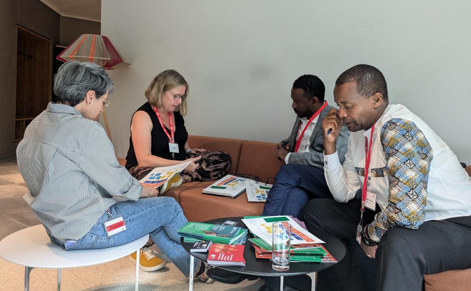 A group of people sit around a low table working together